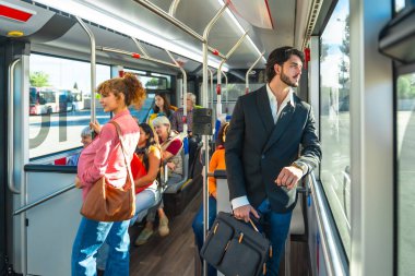 Haftanın her günü şehir otobüsüne binen çeşitli yaş ve etnik kökenli yolcular, bazıları oturuyor, ayakta duruyor, günlük şehir hareketleri ve rutin hareketlerin ortasında pencereden dışarı bakıyor.