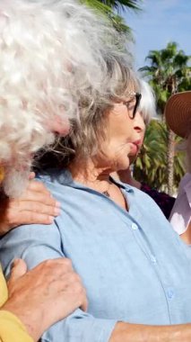 Güneşli bir günde, dışarıda toplanan şık ve şık arkadaşlardan oluşan mutlu bir grup. Gülerek ve gülerek zengin palmiye ağaçlarıyla çevrili gerçek bir neşe ve sürprizle akıllı bir telefona bakıyorlar.