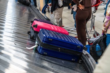 Havaalanı bagajında dinlenen renkli bavullar atlıkarıncaya binerken, yolcular da yolculuk varış noktalarına vardıktan sonra bagajlarını almak için sabırsızlanıyorlar.