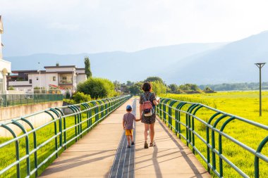 Anne ve oğlu, yeşil yemyeşil ve dağlarla çevrili bir yaya köprüsünde sakin bir gezinti yapıyorlar. Somon kolunun, İngiliz Kolombiyası 'nın, Kanada' nın güzel şehrinde.