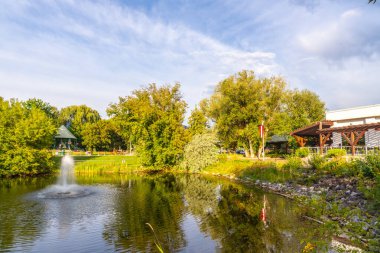 Somon kolunda halka açık bir parkta, İngiliz Kolombiyası, Kanada 'da, yemyeşil ağaçlar ve çardakla çevrili sakin bir havuz, doğanın dingin güzelliğini yansıtıyor.