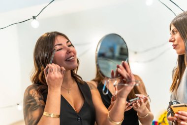 Genç, çeşitli kadınlar birlikte eğleniyorlar. Kozmetik ve sohbet yaparak, güzellik ve arkadaşlığa odaklanarak evde özel bir partiye hazırlanıyorlar.