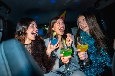 Üç arkadaş özel bir olayı kutluyorlar, gece arabanın arka koltuğunda seyahat ederken renkli kokteyller içip gülüyorlar, birlikte neşeli ve neşeli anılar yaratıyorlar.