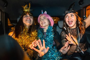 Üç mutlu genç kadın kutlama yapıyor ve gece gezintisi sırasında eğleniyorlar. Şenlikli kostümler ve süslü çelenkler giyiyorlar. Özel bir etkinliğe giderken ya da gelirken kahkaha ve heyecan paylaşıyorlar.