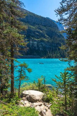 Turistler turkuazda kano geziyor, buzullar Banff Ulusal Parkı 'nın arka planındaki on tepenin manzaralı vadisiyle Moraine Gölü' nü besliyor, Kanada kayalıkları, alberta, Kanada