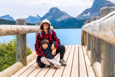 Turistler Banff Ulusal Parkı, Alberta, Kanada 'daki baş döndürücü göl manzarasının tadını çıkarıyorlar. Etrafı görkemli kayalık dağlarla çevrili ve açık havada mükemmel bir yaz gününün tadını çıkarıyorlar.