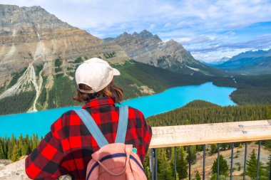 Turkuvaz rengi Peyton Gölü 'nün ve Banff Ulusal Parkı' ndaki dağların, Kanada kayalıklarının, Alberta 'nın, Kanada' nın yaz günlerinin tadını çıkaran kadın yürüyüşçü.