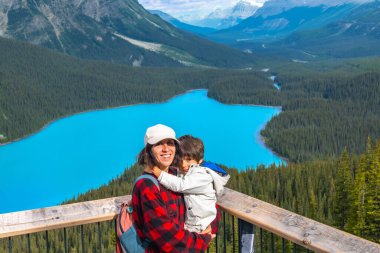 Anne oğlunu kucağında tutarken Peyton Gölü 'nün çarpıcı turkuaz sularına hayran kalıyor. Etrafı bereketli ormanlarla ve Banff Milli Parkı' ndaki görkemli Kanada kayalıklarıyla çevrili.