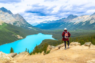 Turkuaz Peyton Gölü 'nün ve Banff Ulusal Parkı' ndaki kayalık dağların nefes kesici manzarasının tadını çıkaran yürüyüşçü, açık hava meraklıları için popüler bir yer.