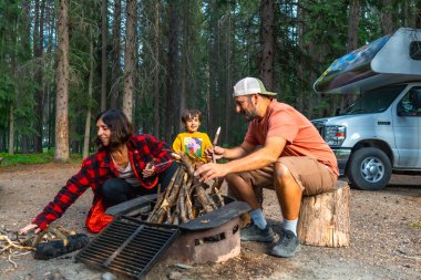 Ailece keyifli bir kamp gezisi, Banff Ulusal Parkı 'ndaki kamp minibüslerinin yanında toplanmak, Kanada' nın Alberta, Kanada 'nın göz kamaştırıcı kayalıklarıyla çevrili