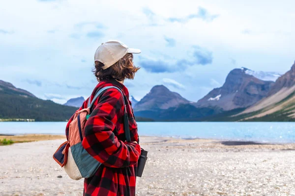 Turkuaz yay gölünün kıyısında duran genç yürüyüşçü bulutlu bir yaz gününde Kanada kayalıklarında Banff Ulusal Parkı 'nın görkemli dağlarını düşünüyordu.