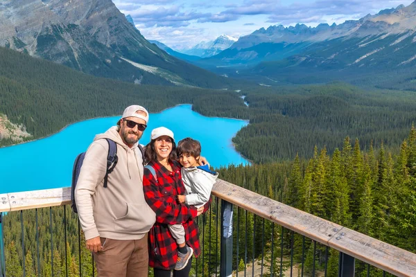 Turistler, güneşli bir günde Banff Ulusal Parkı 'ndaki görkemli Kanadalı kayalıklarla çevrili Peyton Gölü' nün büyüleyici turkuaz sularına hayran kalarak unutulmaz aile anıları yarattılar.
