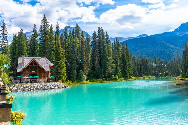 Zümrüt göl kulübesi, yemyeşil çam ağaçlarının arasına kurulmuş, Yoho Ulusal Parkı 'ndaki zümrüt gölünün canlı turkuaz sularına güzel bir şekilde yansıyor.