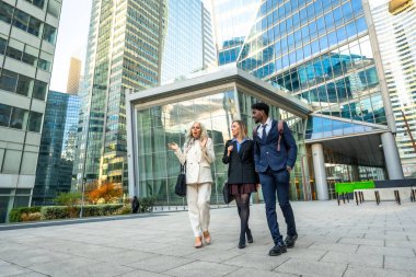 Çağdaş bir finans bölgesinde yürüyen ve tartışan çeşitli iş adamları, işbirliği, kentsel iş hayatı ve uluslararası iş ağlarını yansıtıyorlar.