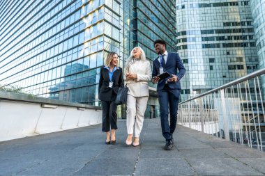 Üç farklı iş adamı. Genç siyah bir adam da dahil. Olgun bir kadın. Ve genç bir kadın. Modern bir şehrin finans bölgesinde yürüyorlar ve gülüyorlar. Projelerde işbirliği