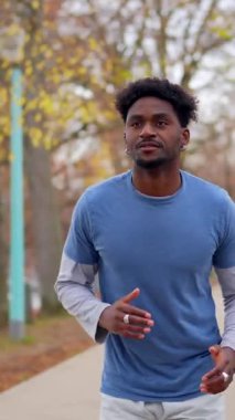 Yakışıklı Afro-Amerikan atleti Paris, Fransa 'daki bir şehir parkında koşuyor ve sağlıklı ve aktif bir şehir yaşam tarzını sürdürüyor.