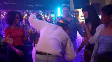 Neşeli arkadaşlardan oluşan çeşitli gruplar renkli neon ışıkları olan canlı bir gece kulübünde kutlama, dans ve kokteyller içiyorlar. Saf neşe ve canlı bir gece hayatı yakalıyorlar.