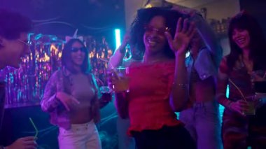 Değişik genç arkadaşlardan oluşan enerjik bir grup canlı bir gece kulübünde dans ediyor ve kokteyller içiyor, renkli mor ve mavi neon ışıklarla aydınlatılıyor, eğleniyor ve hayatı kutluyorlar.