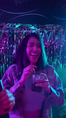 Genç ve çeşitli arkadaşlar canlı bir karaoke gecesinin tadını çıkarıyorlar. Canlı bir partide renkli neon ışıklar altında şarkı söyleyip kokteyller içiyorlar.