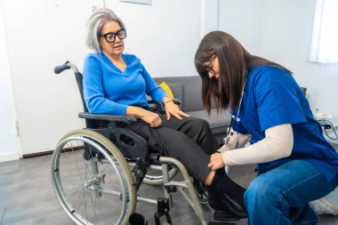 Tekerlekli sandalyedeki yaşlı bir kadına kıyafetleri ile yardım etmek, bir etkinliğe hazırlanmak veya yürümek, yaşlılar için bakım, hareketlilik ve destek temaları