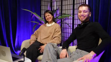 Profesyonel bir kayıt stüdyosunda başarılı bir canlı yayın seansının bitişini kutlayan neşeli erkek ve kadın etkenler beşlik çakıyor ve sonra birbirlerine sarılıyorlar.