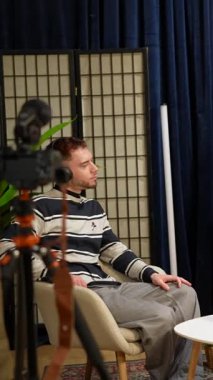 Profesyonel içerik yaratıcılar, iki kadın ve bir erkek, profesyonel kameralar, mikrofonlar ve ışıklandırmanın bulunduğu bir stüdyoda bir podcast veya sosyal medya canlı yayını sırasında konuşuyorlar ve etkileşim halindeler.