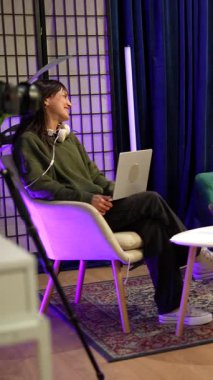 Profesyonel yayın, canlı yayın ve sosyal medya içeriği yaratımı için donanımlı modern bir stüdyoda etkileyici bir konuşma kaydeden bir grup genç nüfuzlu ve podcaster.