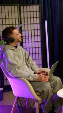 Genç erkek ve kadın içerik yaratıcıları modern bir stüdyoda canlı yayın sırasında el sıkışıyor ve konuşuyorlar. Sosyal medya kanalları için podcast yapmaya hazırlanıyorlar.