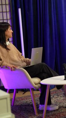 Sosyal medya için içerik yaratan genç adam ve kadın, bir podcast ya da mikrofon ve kamera ile bir röportaj kaydediyor rahat, profesyonel aydınlatılmış modern bir stüdyo içinde bir tripod üzerinde