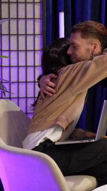 İki genç içerik yaratıcısı, bir erkek ve bir kadın, modern bir stüdyoda mikrofonlarıyla birlikte podcast bölümü kaydediyor, bir röportaj ya da sosyal medya canlı yayınına hazırlanıyorlar.