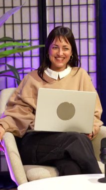 İki genç içerik yaratıcısı, bir erkek ve bir kadın, canlı bir sohbete dalarken podcast yaparken ya da profesyonel bir stüdyoda mor ışıklı canlı yayın yaparken