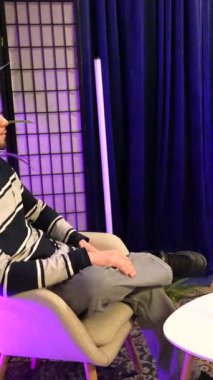 İçerik yaratıcıları profesyonel ışıklandırma ve mikrofonları olan modern bir stüdyoda bir podcast veya röportaj programı kaydediyor, sosyal medya seyircileri ve çevrimiçi yayın konularını tartışıyorlar.