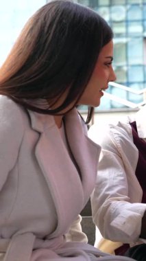 Şehirdeki merdivenlerde birlikte oturan genç iş adamları, mola sırasında bir dizüstü bilgisayarda bir proje üzerinde işbirliği yapıyor ve tartışıyorlar, takım çalışması ve modern şehir iş hayatını gözler önüne seriyorlar.