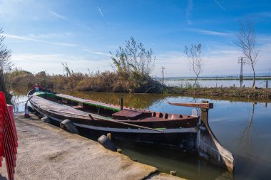 Geleneksel Barca de l 'albufera tarihi el palmar' da bir beton iskeleye demirlemiş. Albufera doğal parkı sulak alanlarındaki veda lagünü kültürünü yansıtıyor.