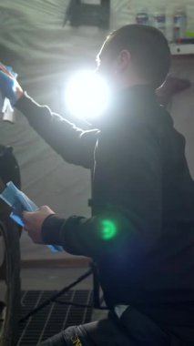 Garajda çalışkan bir otomobil tamircisi dikkatli bir şekilde arabaların yüzeyini mikrofiber bezle siliyor ve cilalıyor. Detaylı bir inceleme sırasında parlak bir denetim ışığı altında mükemmel bir son garantiliyor.