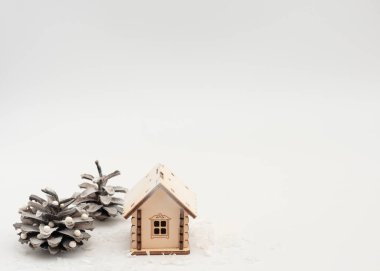 Beyaz arka planda süslü Noel ağacı gibi kozalaklı, karlı ahşap bir ev. Noel boyunca evde kalmak, yeni yıl tatili konsepti. İzolasyon ve koronavirüs salgını. Kış kartı. 