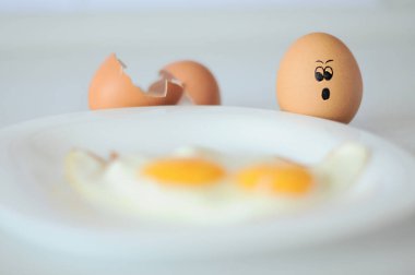 Çiğ yumurta ve gözleri bulanık yumurtalara dehşetle bakıyor. Tavuk yumurtası yenmekten korkar. Seçici odak, bulanık resim. 
