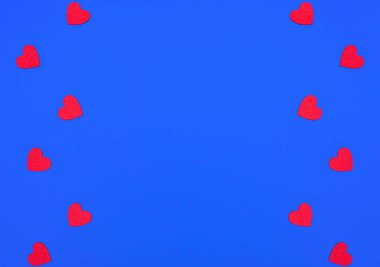 Mavi arka planda keçeli kırmızı kalpler olan sevgililer günü sahnesi. Aşk konsepti. Fotokopi alanı olan minimal düz stil. Selamlama veya davet kartı.