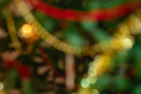 Resumen desenfocado fondo de Navidad o Año Nuevo con borroso árbol de Navidad decorado de cerca. Concepto de vacaciones. Tarjeta de felicitación o invitación — Foto de Stock