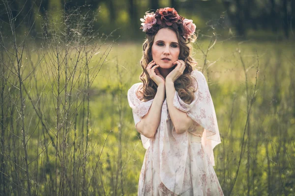 Joven chica bonita está posando con flores —  Fotos de Stock