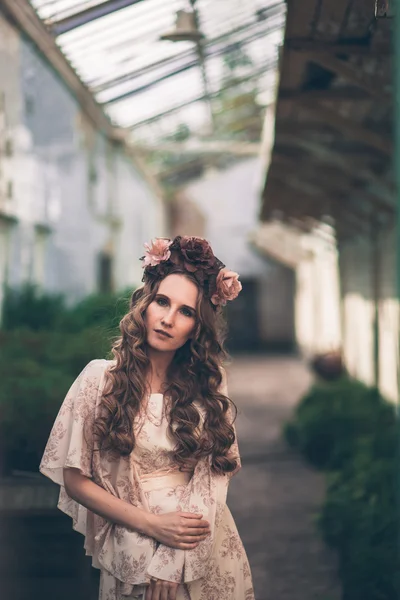 Joven chica bonita está posando con flores — Foto de Stock