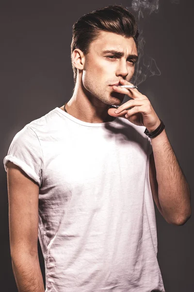 Handsome young man smoking cigarette — Stock Photo, Image