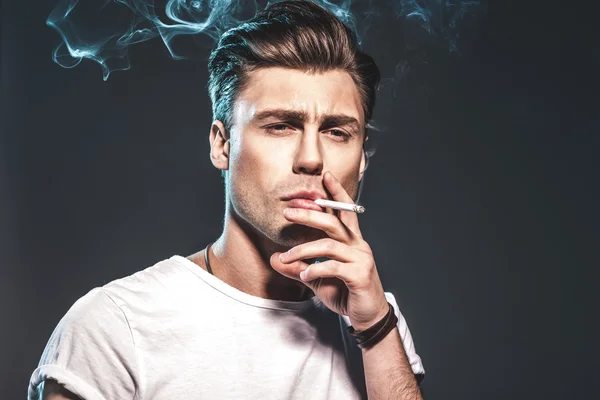 Handsome young man smoking cigarette — Stock Photo, Image