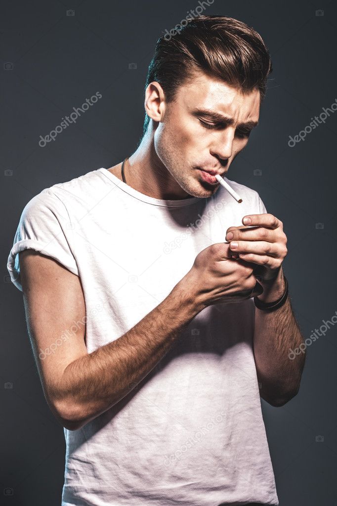 Handsome young man smoking cigarette