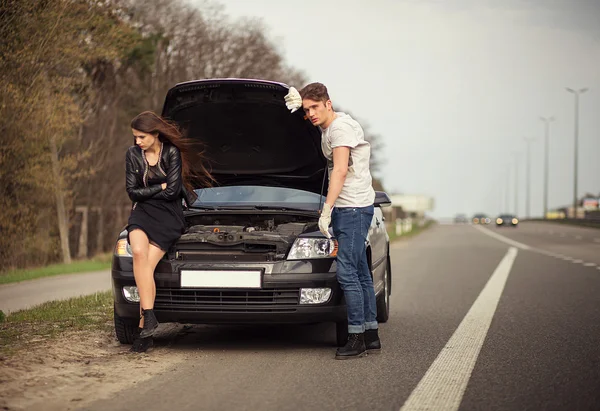 Couple near a broken car on the roadside — Stock Photo, Image