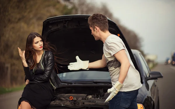 Couple près d'une voiture cassée sur le bord de la route — Photo