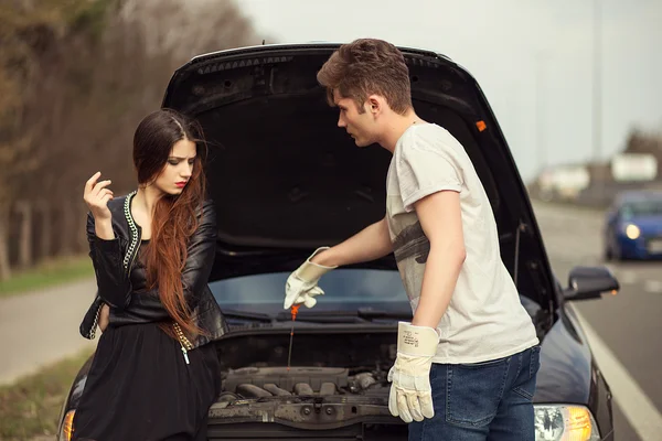 Couple near a broken car on the roadside — Stock Photo, Image