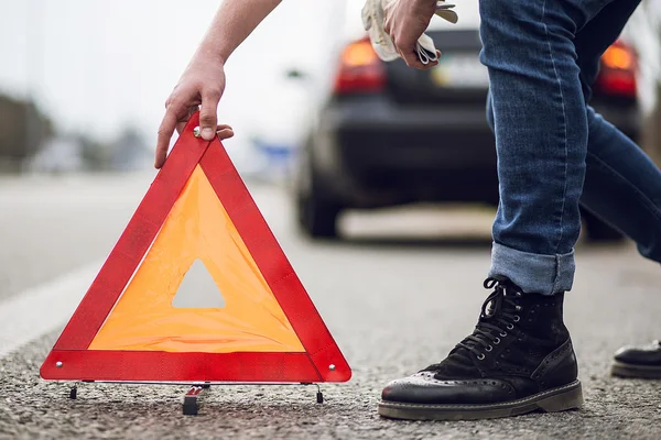 Auto con guasto lungo la strada, l'uomo imposta triangolo di avvertimento — Foto Stock