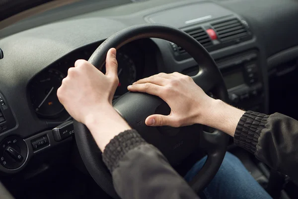 Close-up of  male hand on steering wheel in car — Stock Photo, Image