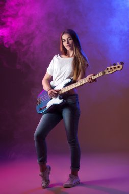 beautiful girl in the studio, bright blonde, playing guitar